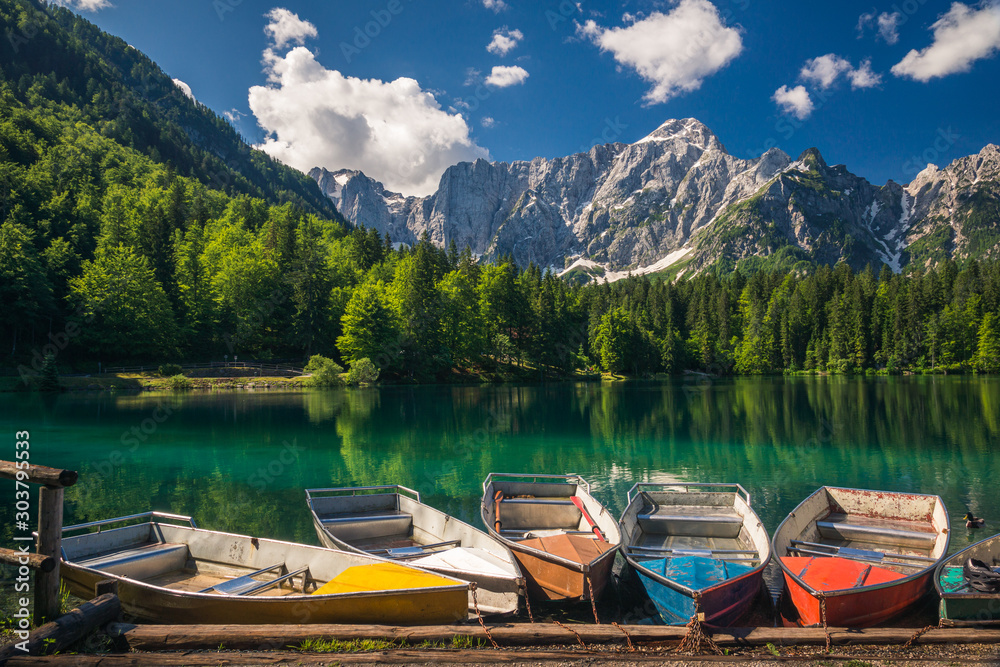 Colorful boats on Lake Fusine on the slopes of the Julian Alps, Tarvisio, Italy