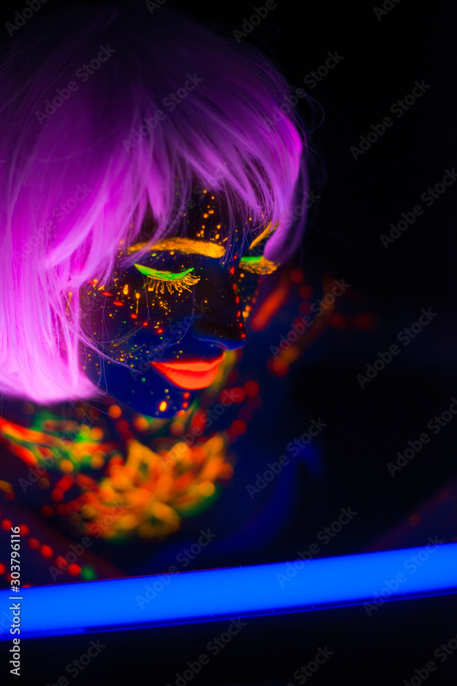 Portrait of Beautiful Fashion Woman in Neon UF Light. Model Girl with Fluorescent Creative Psychedelic MakeUp, Art Design of Female Disco Dancer Model in UV, Colorful Abstract Make-Up. Dancing Lady