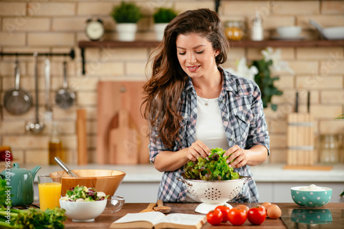 Young woman in kitchen. Beautiful woman making healthy food.