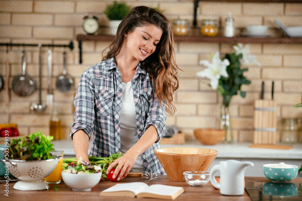 Young woman in kitchen. Beautiful woman preparing healthy food.