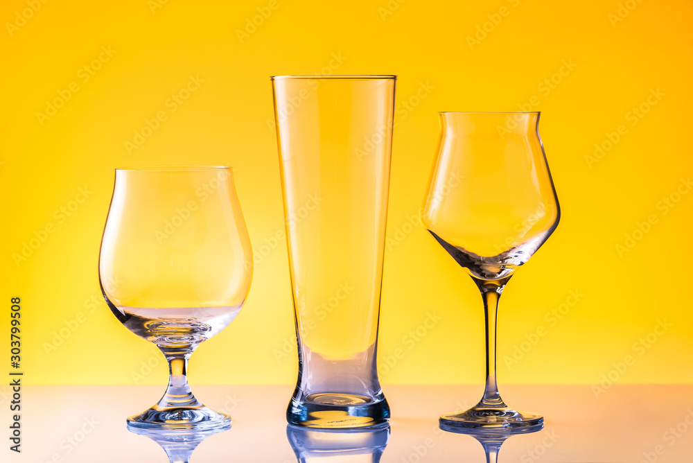 Set with three different empty beer glasses on white golden background. Alcohol concept Set with three different empty beer glasses on white golden background. Alcohol concept