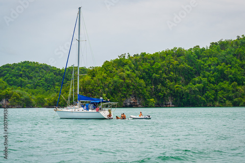 Luxury boat anchored close to exotic tropical island. Panoramic landscape view of Los Haitises natural park,Samana peninsula in Dominican republic.