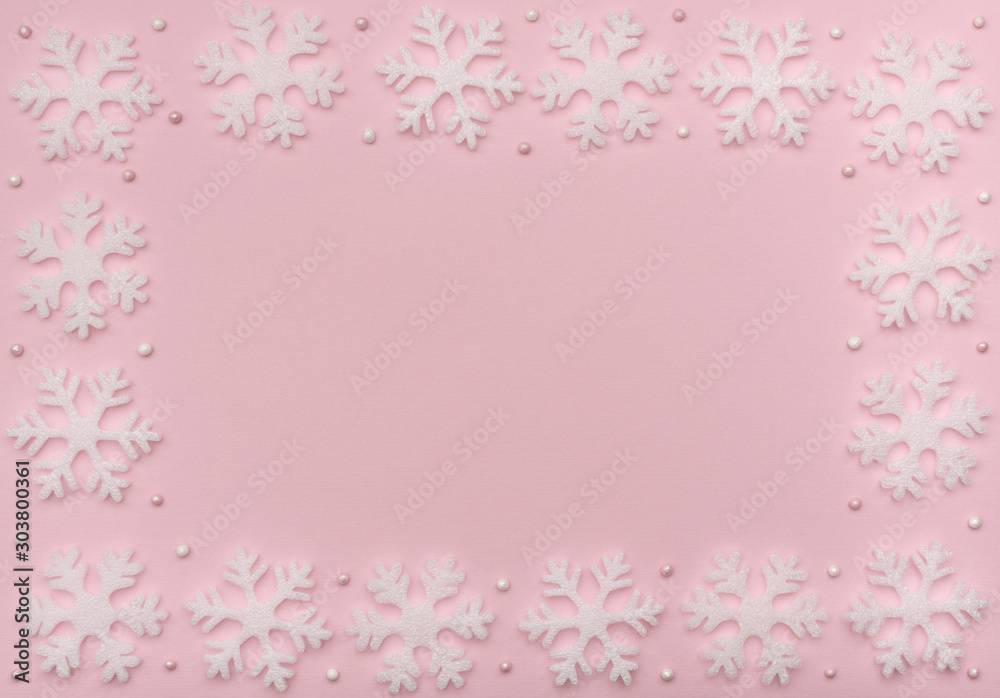 Christmas pink background with white snowflakes and beads. New Year greeting card. Flat lay style. Christmas pink background with white snowflakes and beads. New Year greeting card. Flat lay style.