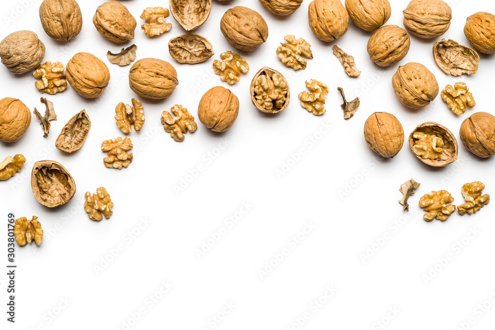 top view of walnuts closed and broken scattered on a white background with copy space top view of walnuts closed and broken scattered on a white background with copy space