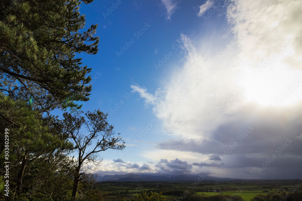 Obraz premium Beautiful vista of the Snowdonia Mountain range from Pentraeth Forest with angry storm clouds approaching from the south, Isle of Anglesey, North Wales