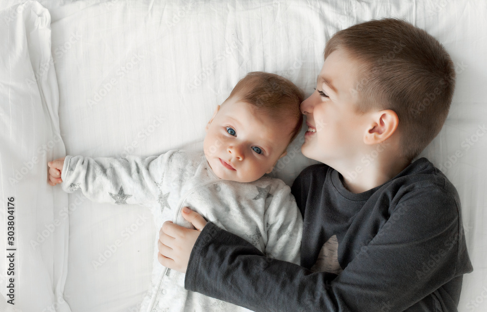 children lie on the bed and interact with each other. children lie on the bed and interact with each other.