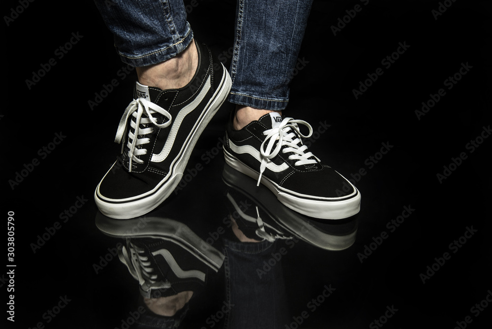 Young man wearing brand new black and white Vans Old Skool shoes Stock  Photo | Adobe Stock