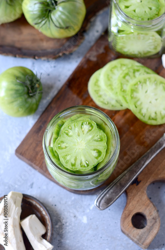Pickled green tomatoes with herbs, horseradish, pepper and garlic