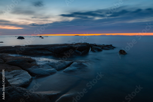 Sunset sky over stones and flat rock sinking under Baltic sea. Amazing wilderness of Estonia. © yegorov_nick