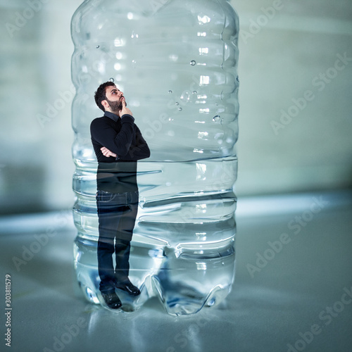 Bilde på lerret Man trapped inside plastic bottle. Plastic free concept.