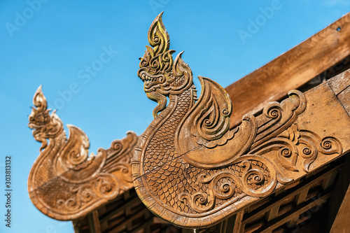 Wooden dragons carved decoration on the roof of buddhist temple  Thailand.