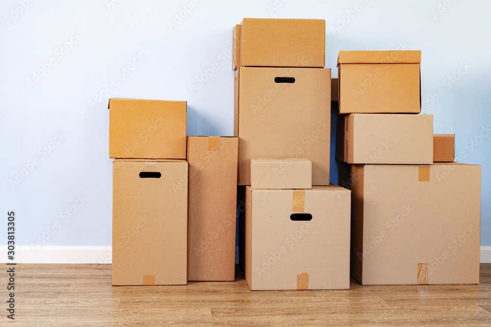 House moving concept with stacked cardboard boxes in a room House moving concept with stacked cardboard boxes in a room