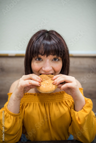 Cute girl sits a cafe with fast food