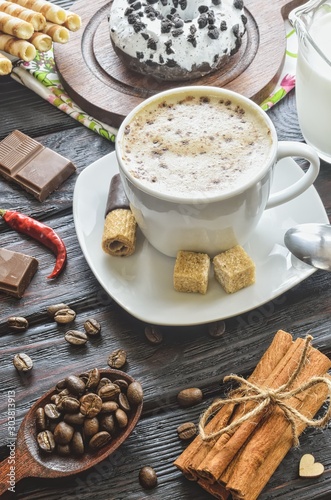 Elegant concept of serving coffee in vintage style. Coffee with foam and cinnamon with various sweets and decoration.