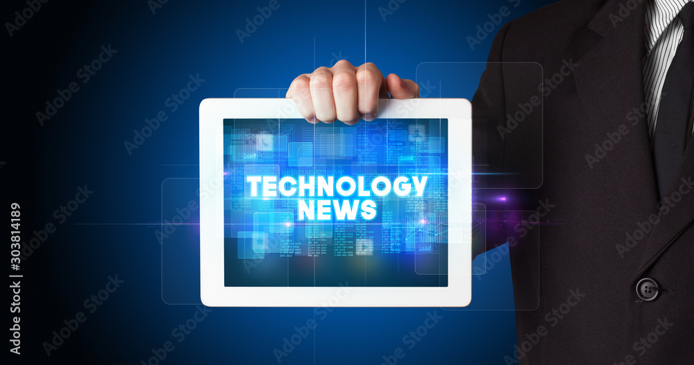 Young business person working on tablet and shows the inscription: TECHNOLOGY NEWS Young business person working on tablet and shows the inscription: TECHNOLOGY NEWS