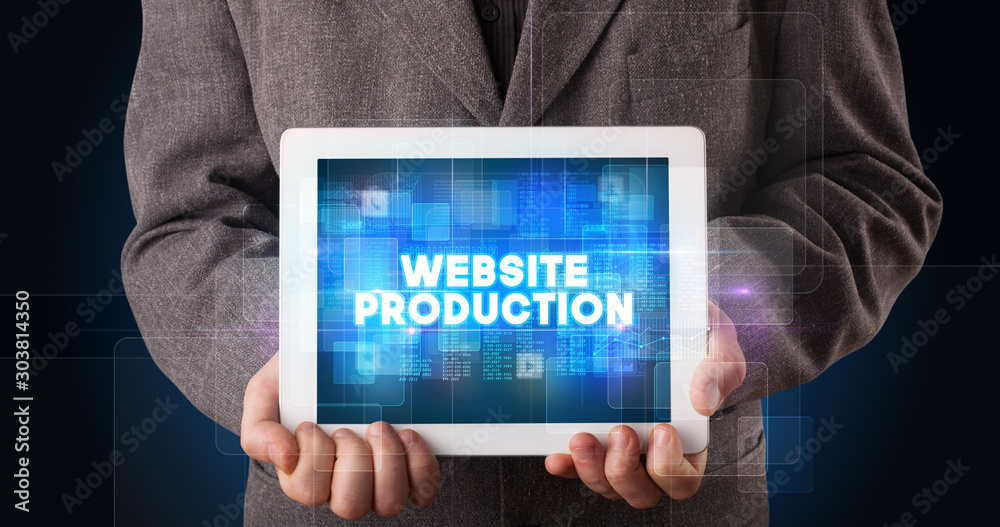 Young business person working on tablet and shows the inscription: WEBSITE PRODUCTION Young business person working on tablet and shows the inscription: WEBSITE PRODUCTION