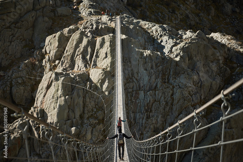 Mountaineers crossing the suspension bridge of Trift (Triftbrücke). Switzerland photo