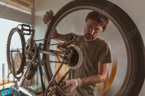 Bicycle mechanic repairing old mountain bike in workshop