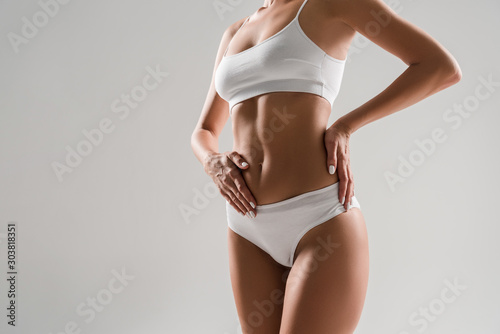 Quadro su tela cropped view of beautiful slim woman in underwear isolated on grey