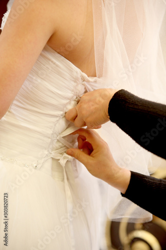 the hand that ties up the bride's dress