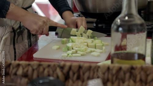 A zucchini being cut in the kitchen with a big knife photo