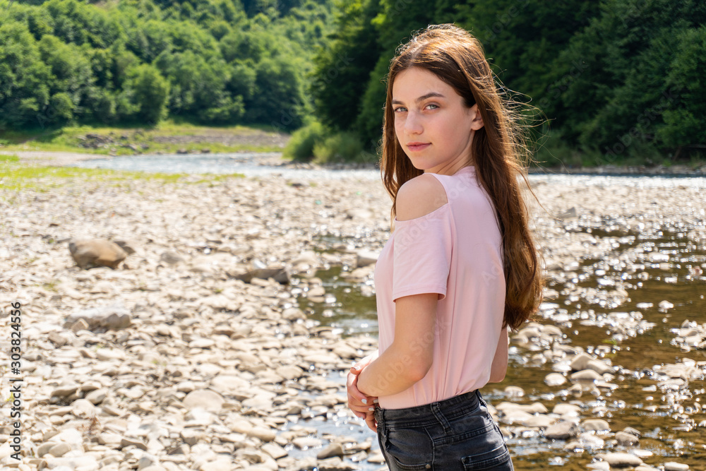 Φωτογραφία Teenager woman girl looking in camera standing near mountain river