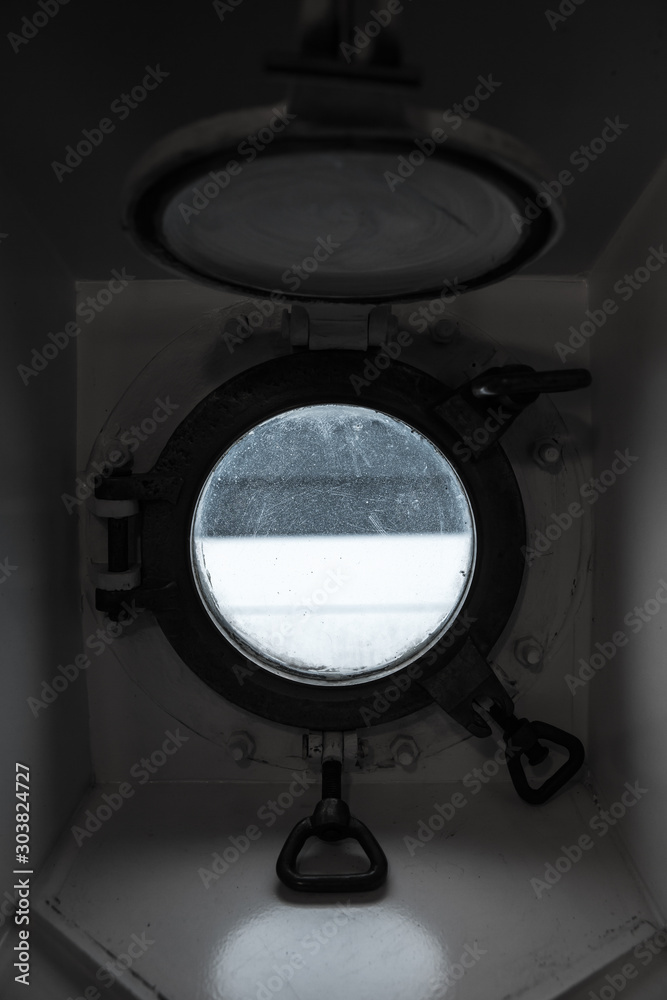Open round porthole in dark ship cabin Open round porthole in dark ship cabin
