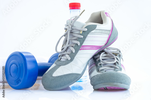 Blue plastic coated dumbells and water bottle,sneakers and towel isolated on white