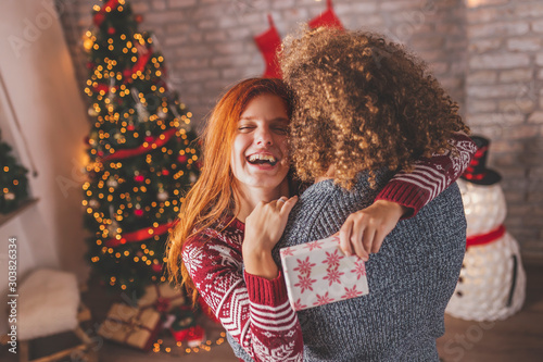 Couple having fun while exchanging Christmas presents