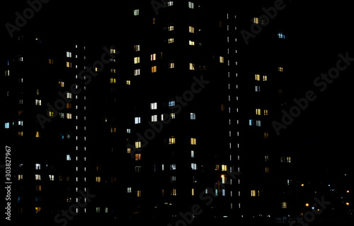 Flashing light in the window of a multi-storey building made of glass and steel lighting closeup view. In the dark