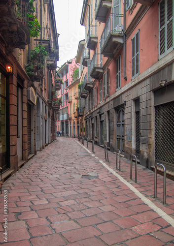 a narrow street in the historic center of Milan with nineteenth-century stone paving