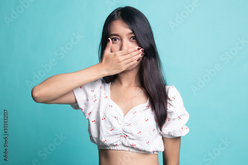 Young Asian woman close her mouth with hand.
