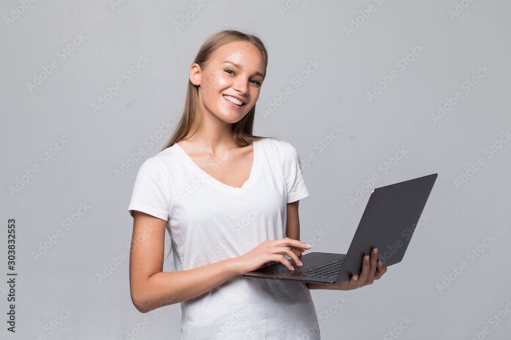 Portrait of a smiling girl holding laptop computer isolated on a white background Portrait of a smiling girl holding laptop computer isolated on a white background