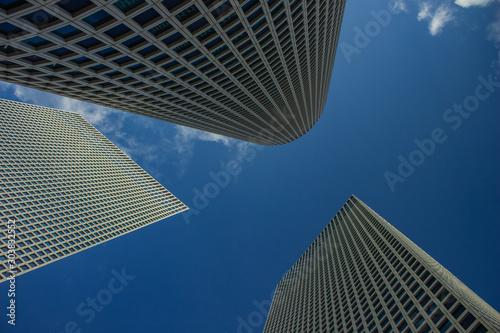 modern city frame work urban view foreshortening from below on three skyscraper towers exterior and blue sky background  