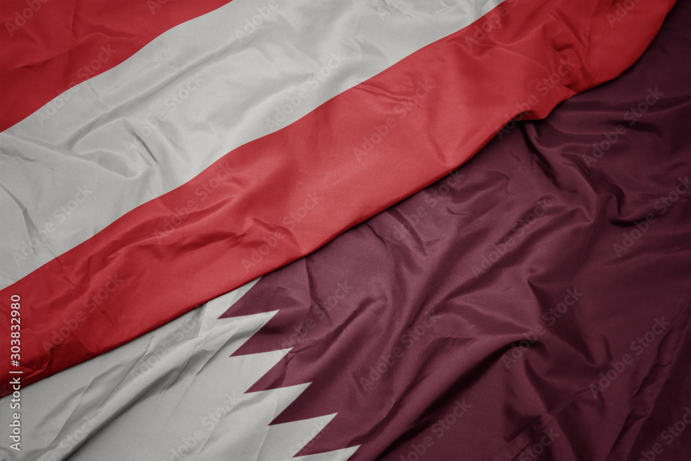 waving colorful flag of qatar and national flag of austria.