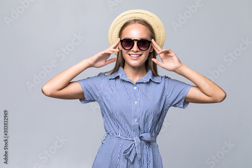 Young attractive hipster teen girl in sunglasses and straw hat isolated on white background