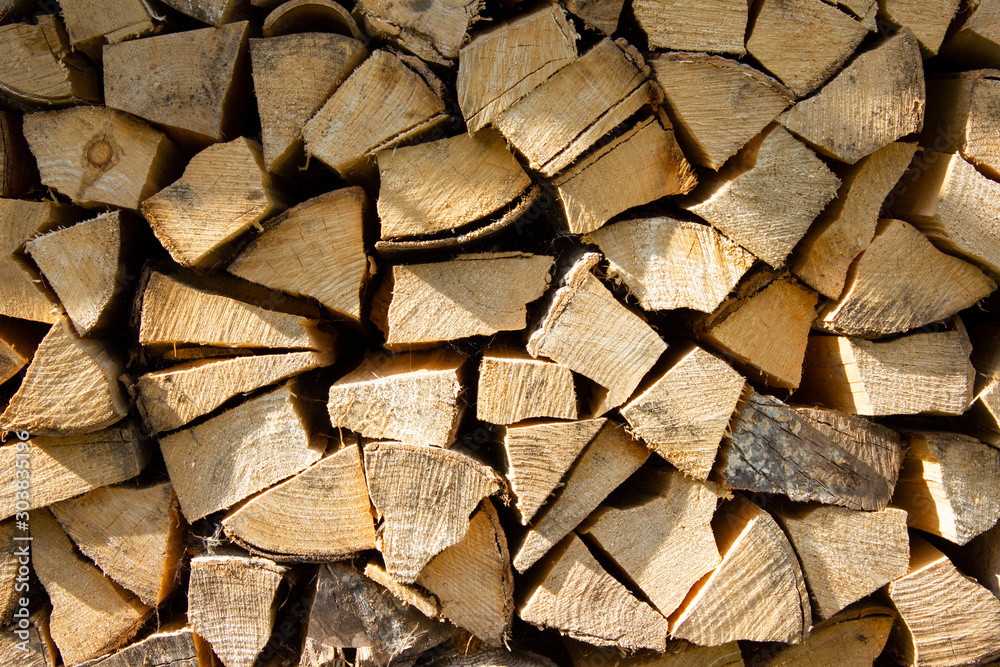 Close up of chopped pine firewood logs stacked against a wall seen front on. Close up of chopped pine firewood logs stacked against a wall seen front on.