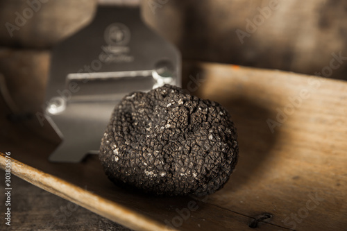 Black Truffle on wood background with Truffle Slicer