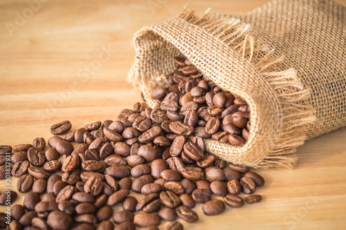 Sack of coffee beans on wooden background © tendo23