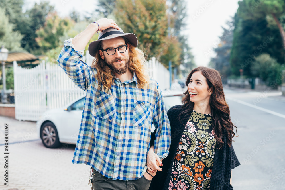 Happy beautiful couple in love walking throughfare holding hands