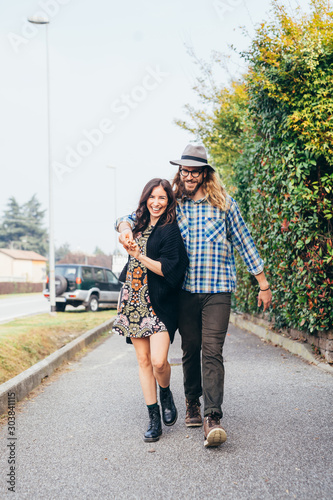 Happy beautiful couple in love walking throughfare holing hands photo