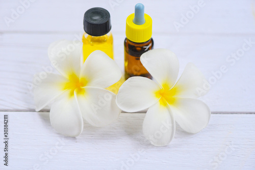 Aromatherapy herbal oil bottles aroma with white flower Frangipani Plumeriaon - Essential oils natural on wooden table and organic minimalist