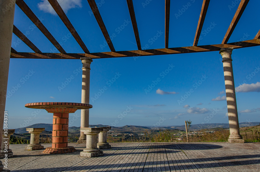 A place to relax on a hill overlooking the houses below. Table and chairs made of stone, roof, gazebo. Portugal A place to relax on a hill overlooking the houses below. Table and chairs made of stone, roof, gazebo. Portugal
