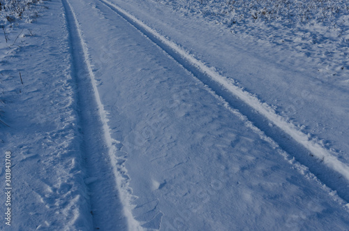 car tracks in the snow on a cold morning