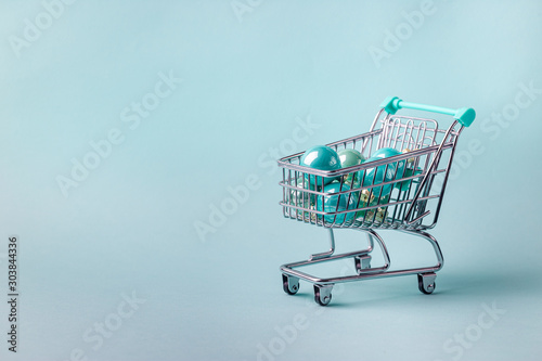 shopping cart full of christmas presents on bright blue background