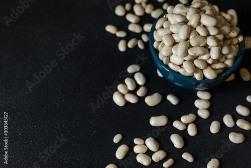 healthy white beans in a dark gray background