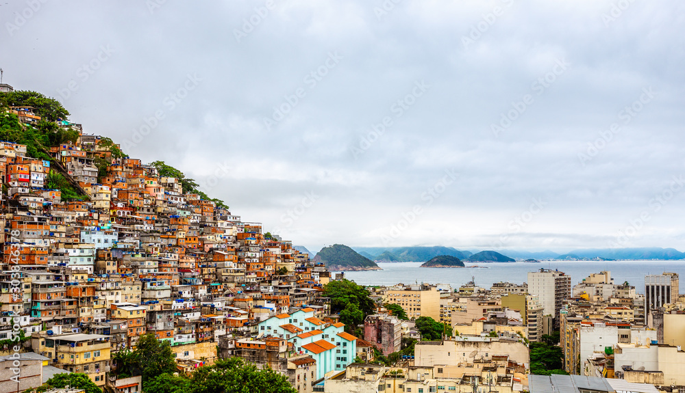 Fotografie Brazilian favelas on the hill with city downtown below at the tropical bay, Rio