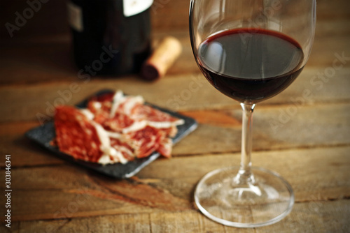 Spanish typical Iberian ham and red wine on wood
