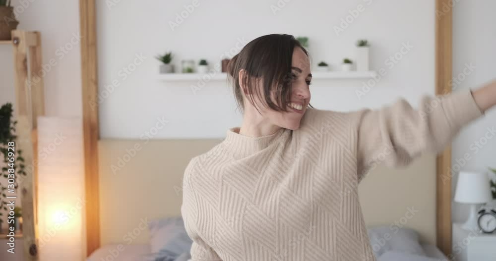 Carefree young woman dancing in her bedroom Carefree young woman dancing in her bedroom