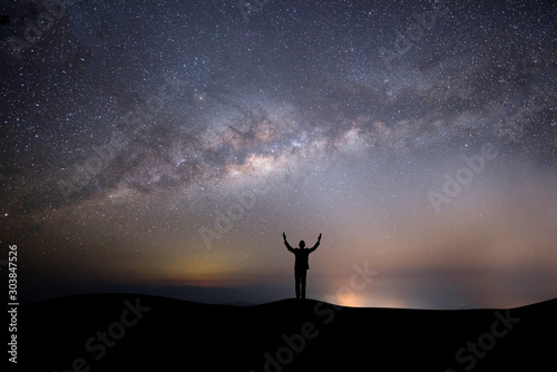 silhouette successful man on the top of the hill on a background with stars